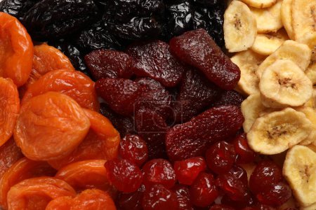Téléchargez les photos : Différents délicieux fruits secs comme fond, vue de dessus - en image libre de droit