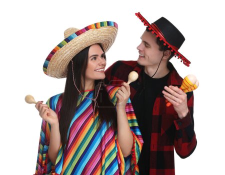 Téléchargez les photos : Joli couple en sombrero mexicain chapeaux avec maracas sur fond blanc - en image libre de droit