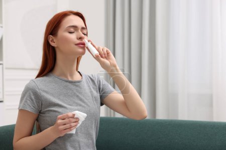 Photo for Medical drops. Woman with tissue using nasal spray at home, space for text - Royalty Free Image