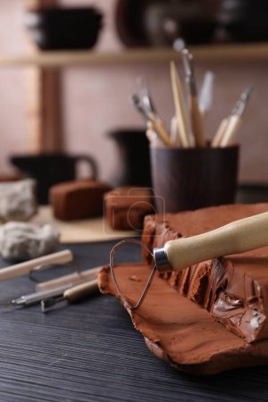 Outil en argile et boucle sur table en bois gris foncé en atelier