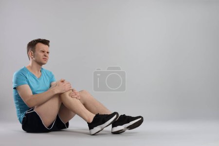 Photo for Man suffering from leg pain on grey background. Space for text - Royalty Free Image