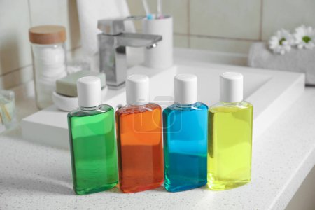 Frische Mundspülungen in Flaschen auf Arbeitsplatte in der Nähe des Waschbeckens, Nahaufnahme