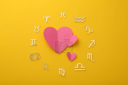 Foto de Signos del zodíaco y corazones rosados sobre fondo amarillo, planas - Imagen libre de derechos