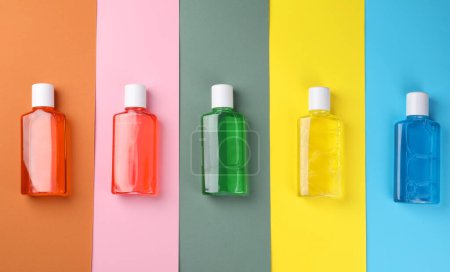 Foto de Enjuagues bucales frescos en botellas sobre fondo de color, planas - Imagen libre de derechos