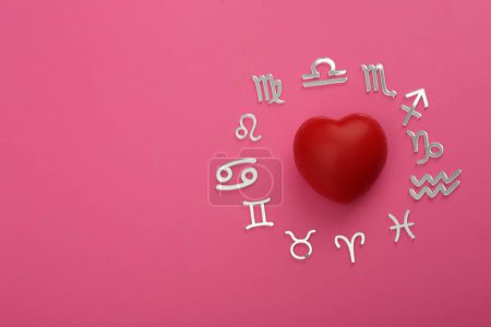 Zodiac signs and red heart on pink background, flat lay. Space for text
