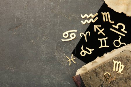Foto de Signos del zodíaco, libro viejo y carta sobre tabla texturizada gris, puesta plana. Espacio para texto - Imagen libre de derechos