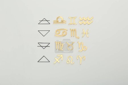 Foto de Triplicidad del zodíaco. Cuatro elementos y signos correspondientes sobre fondo gris, plano - Imagen libre de derechos