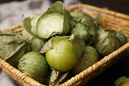 Tomatillos verts frais avec balle dans le panier en osier sur la table, gros plan