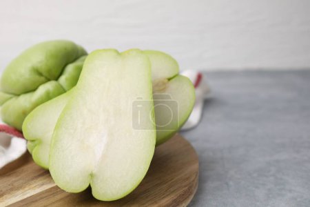 Photo for Cut and whole chayote on gray table, closeup. Space for text - Royalty Free Image