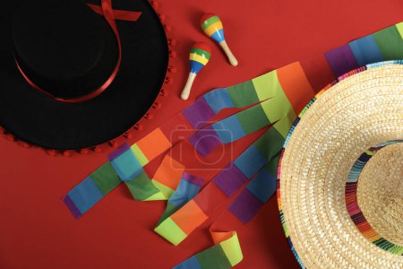 Téléchargez les photos : Sombrero mexicain et noir Chapeaux de flamenco et maracas sur fond rouge, couché plat - en image libre de droit