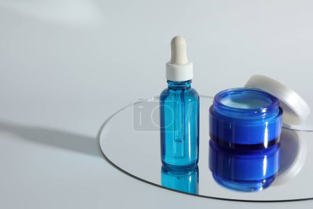 Photo for Bottle and jar with cosmetic products on light background, space for text - Royalty Free Image