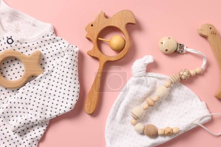 Diferentes accesorios para bebés sobre fondo rosa, cama plana