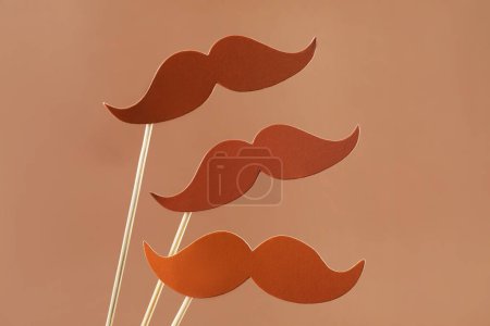 Téléchargez les photos : Faux papier moustaches accessoires de fête sur fond brun clair - en image libre de droit