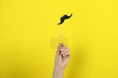 Téléchargez les photos : Femme avec fausse moustache en papier sur fond jaune, gros plan - en image libre de droit