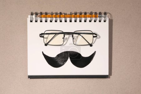 Téléchargez les photos : Composition à plat avec moustache artificielle et verres sur fond brun clair - en image libre de droit