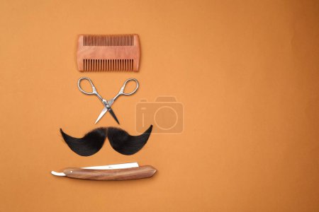 Téléchargez les photos : Moustache artificielle et outils de coiffeur sur fond orange, pose plate. Espace pour le texte - en image libre de droit