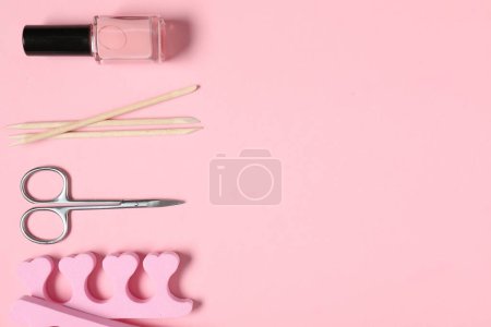 Foto de Esmalte de uñas, palos naranjas, tijeras y separadores de dedos sobre fondo rosa, posición plana. Espacio para texto - Imagen libre de derechos