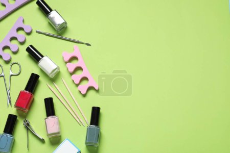 Foto de Esmaltes de uñas y conjunto de herramientas de pedicura sobre fondo verde, planas. Espacio para texto - Imagen libre de derechos