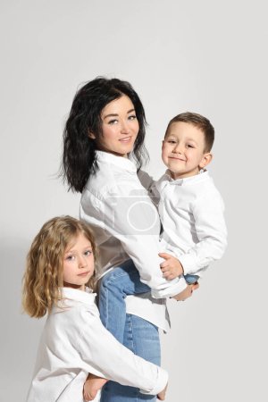 Niños pequeños con su madre sobre fondo blanco