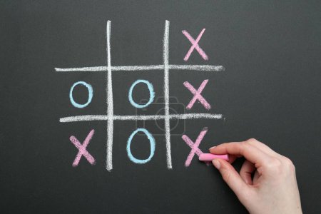 Photo for Woman playing tic tac toe on chalkboard, closeup - Royalty Free Image