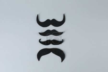 Téléchargez les photos : Moustaches en faux papier sur fond gris, pose plate - en image libre de droit