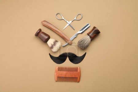Téléchargez les photos : Moustache artificielle et outils de coiffeur sur fond beige, pose plate - en image libre de droit