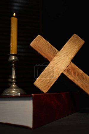 Kerze, Bibel und Holzkreuz auf dem Tisch