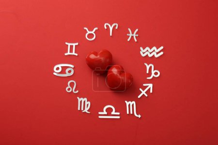 Foto de Signos del zodíaco y corazones sobre fondo rojo, acostado plano - Imagen libre de derechos