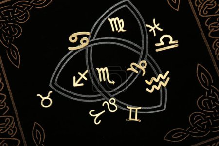 Foto de Signos del zodíaco en libro oscuro, acostado plano - Imagen libre de derechos