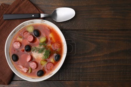 Téléchargez les photos : Soupe de viande solyanka avec de fines saucisses fumées sèches dans un bol sur une table en bois, vue sur le dessus - en image libre de droit