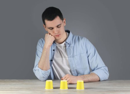 Man playing shell game at wooden table