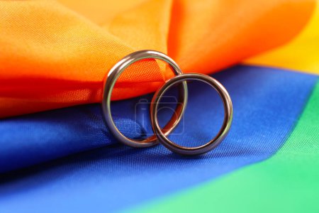 Anneaux de mariage sur drapeau LGBT arc-en-ciel, gros plan