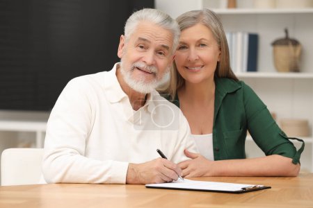Glückliches Senioren-Paar unterzeichnet Testament und Testament