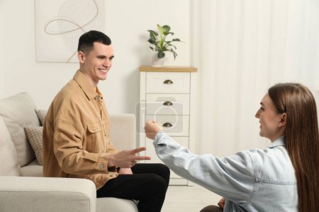 Photo for Happy people playing rock, paper and scissors in room - Royalty Free Image