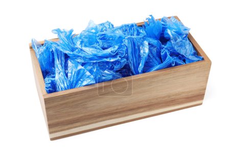 Blue medical shoe covers in wooden crate isolated on white