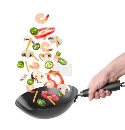 Photo for Man tossing ingredients in wok on white background, closeup - Royalty Free Image