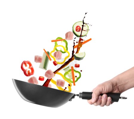 Photo for Man tossing ingredients in wok on white background, closeup - Royalty Free Image