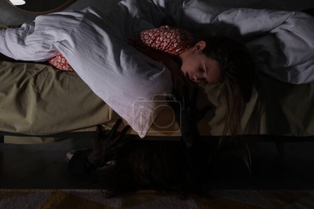 Photo for Childhood phobia. Sleepy girl and monster under bed at home - Royalty Free Image