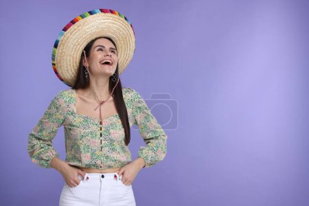 Mujer joven con sombrero mexicano sobre fondo violeta. Espacio para texto