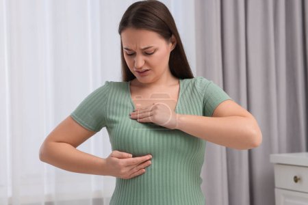 Mammologie. Femme faisant l'auto-examen des seins à la maison