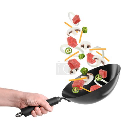 Man tossing ingredients in wok on white background, closeup