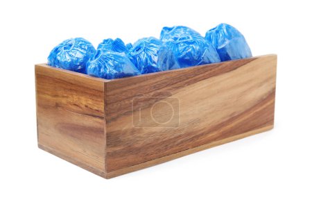Rolled blue shoe covers in wooden crate isolated on white