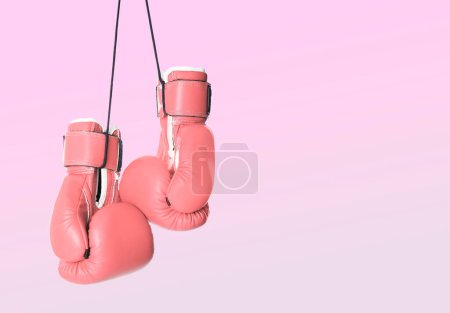 Cancer du sein. Paire de gants de boxe roses sur fond de couleur, espace pour le texte