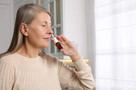 Photo for Medical drops. Woman using nasal spray indoors, space for text - Royalty Free Image