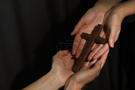 Photo for Easter - celebration of Jesus resurrection. Women holding wooden cross on dark background, closeup. Space for text - Royalty Free Image