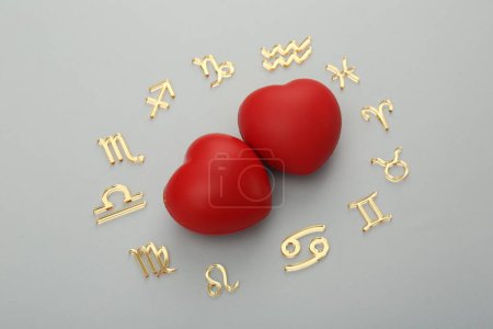 Foto de Signos del zodiaco y corazones rojos sobre fondo gris, acostado plano - Imagen libre de derechos