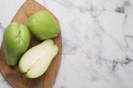 Photo for Fresh green chayote on light marble table, top view. Space for text - Royalty Free Image