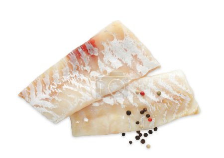 Foto de Filetes frescos de bacalao crudo con granos de pimienta aislados en blanco, vista superior - Imagen libre de derechos