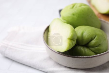 Photo for Cut and whole chayote in bowl on table, closeup. Space for text - Royalty Free Image