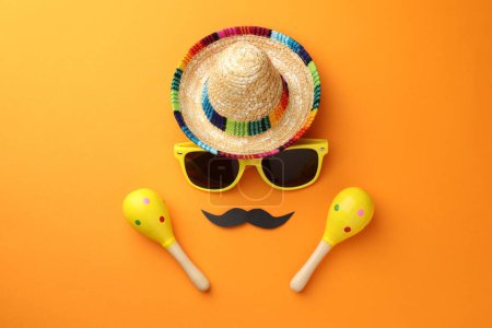 Téléchargez les photos : Chapeau sombrero mexicain, lunettes de soleil, fausse moustache et maracas sur fond orange, plat - en image libre de droit